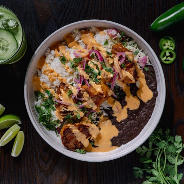 Str8 up Tacos' Mexican rice bowl with crispy pork, black beans, red onion, cilantro, and sauce.